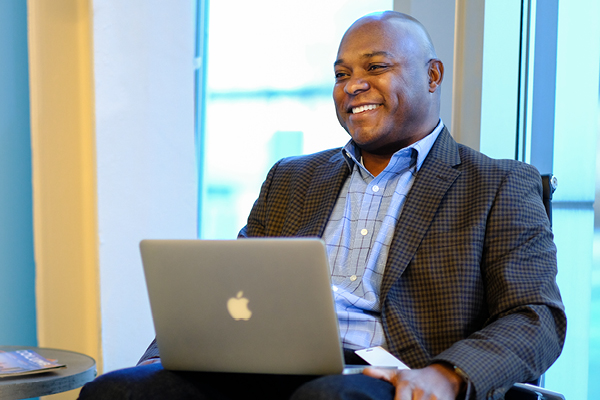 Business man smiling with a laptop in front of him