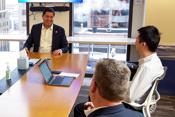 3 men sitting around a conference room table